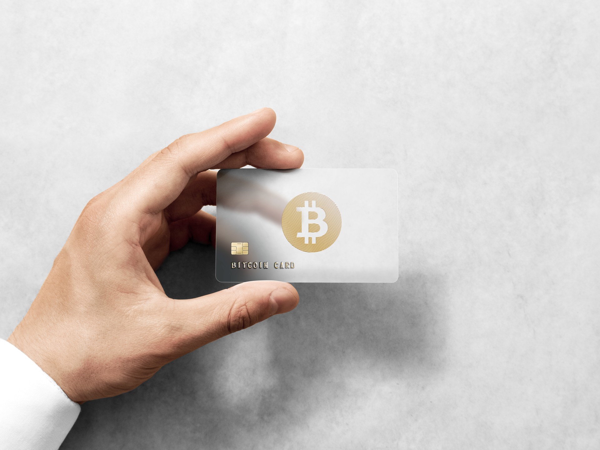 Hand holding bitcoin card template with embossed gold logo